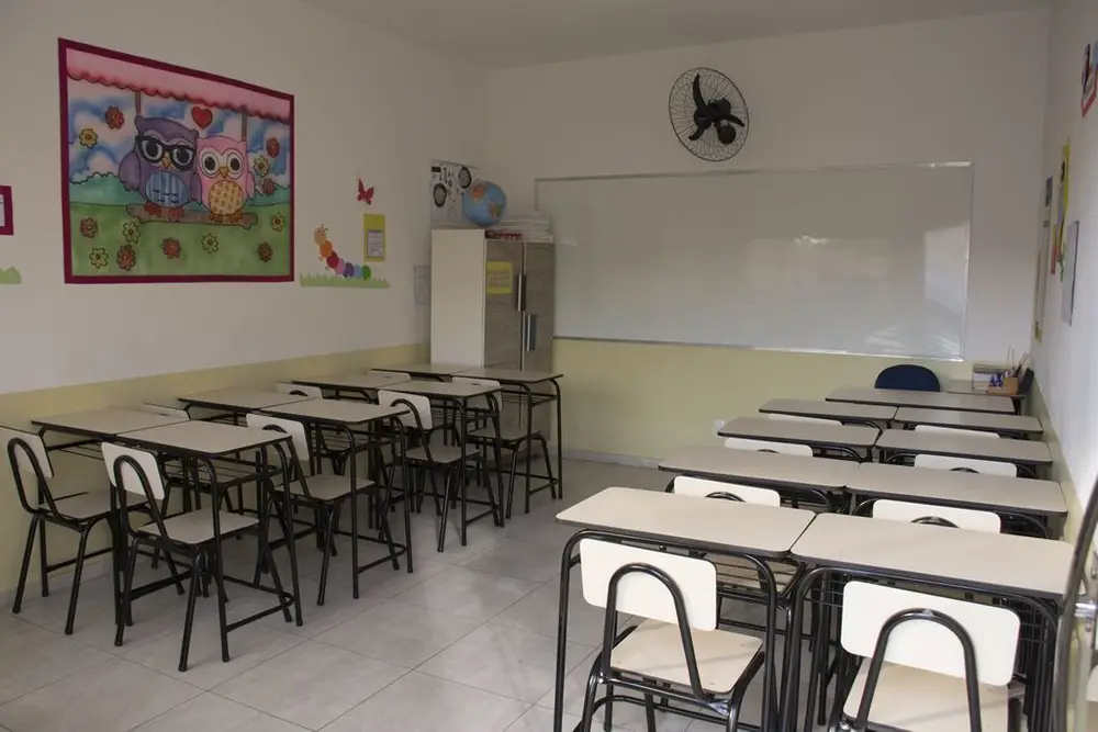 Sala de aula organizada com carteiras e lousa branca do Colégio Barcelos