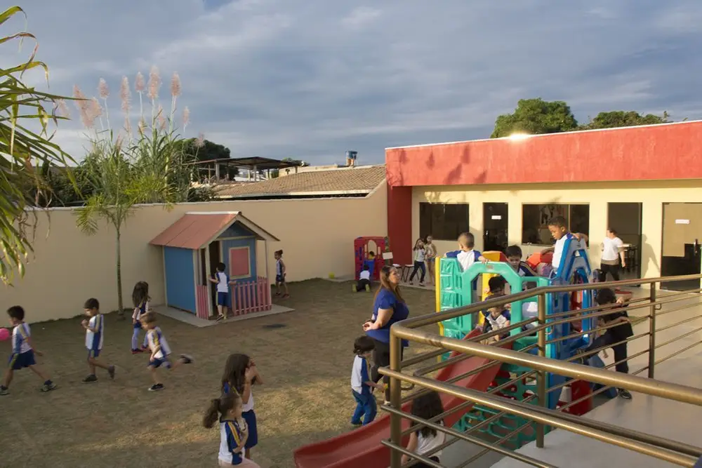 Pátio externo com playground e casinha de brinquedo do Colégio Barcelos