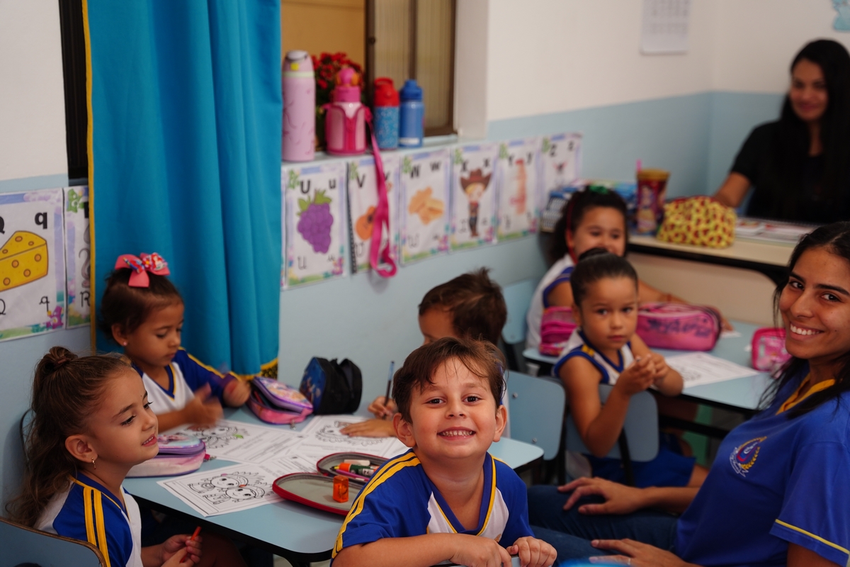 Ambiente de aprendizagem com alunos e professora em sala de aula no Colégio Barcelos